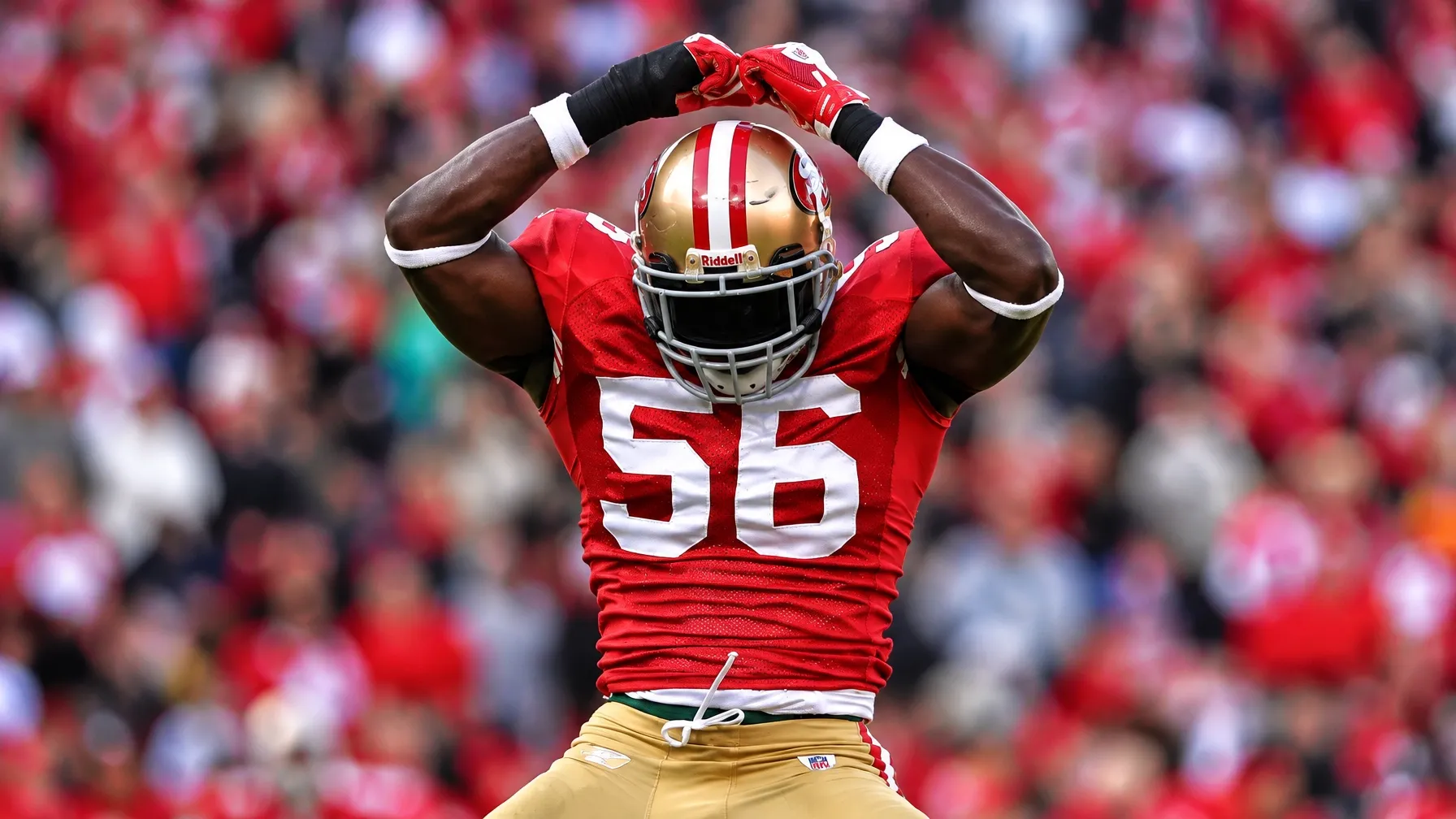San Francisco 49ers number 56 raising his arms in a red uniform